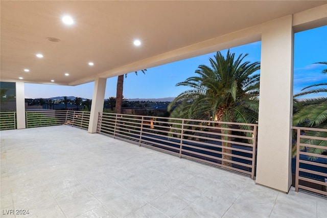 patio terrace at dusk featuring a balcony