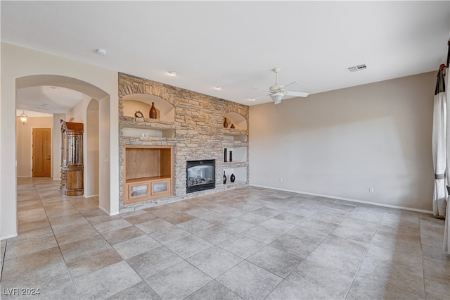 unfurnished living room with ceiling fan and a fireplace