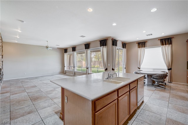 kitchen featuring ceiling fan, an island with sink, light tile patterned flooring, white dishwasher, and sink