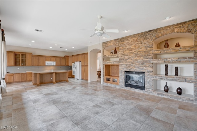 unfurnished living room with ceiling fan and a fireplace