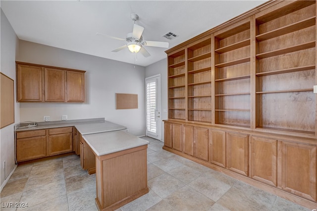 kitchen featuring kitchen peninsula, built in desk, ceiling fan, and light tile patterned flooring