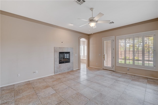 unfurnished living room featuring ceiling fan, a fireplace, and ornamental molding