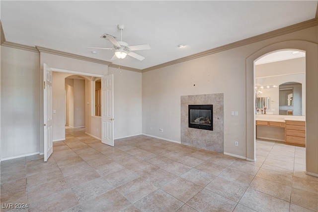 unfurnished living room featuring a fireplace, ornamental molding, and ceiling fan