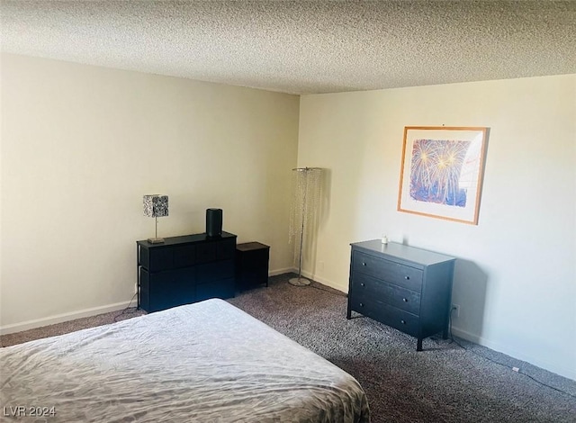 bedroom with dark carpet and a textured ceiling