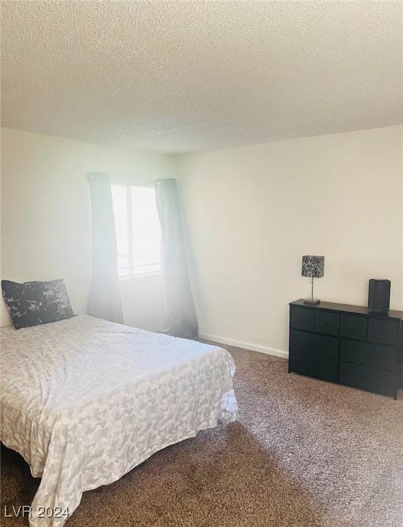 carpeted bedroom featuring a textured ceiling