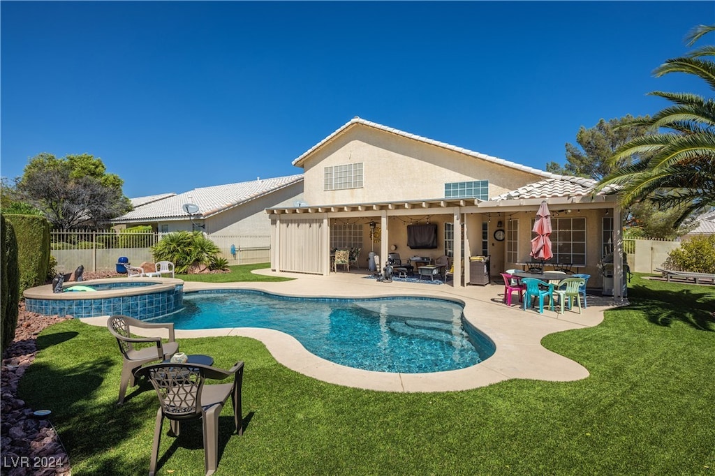 view of swimming pool with a patio, a lawn, and an in ground hot tub