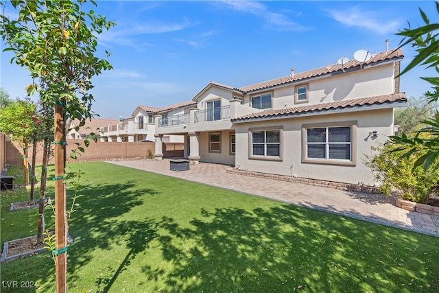 back of house with a balcony, a yard, and a patio