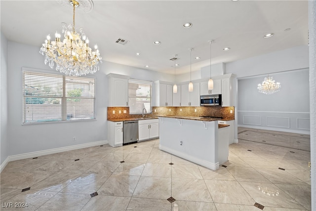 kitchen featuring pendant lighting, sink, backsplash, white cabinetry, and appliances with stainless steel finishes