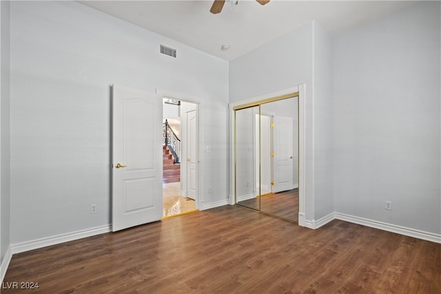 unfurnished bedroom with ceiling fan, dark hardwood / wood-style floors, and a closet