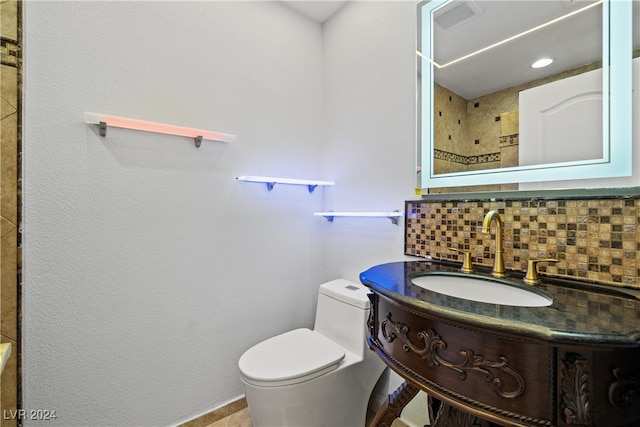 bathroom with vanity, toilet, and decorative backsplash