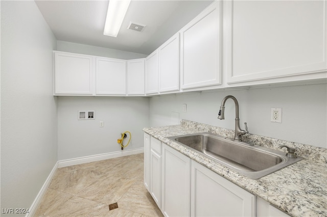 washroom with hookup for a washing machine, cabinets, sink, and light tile patterned floors