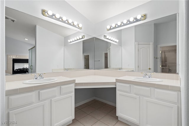 bathroom featuring walk in shower, lofted ceiling, tile patterned flooring, and vanity