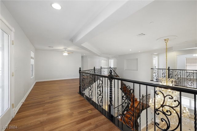 hallway with a notable chandelier and hardwood / wood-style flooring