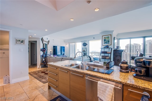 kitchen featuring light stone countertops, dishwasher, light tile patterned floors, and sink