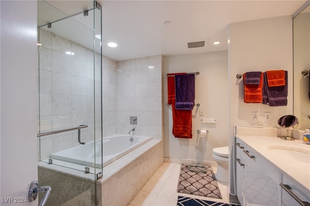 full bathroom featuring tile patterned flooring, tiled shower / bath, vanity, and toilet