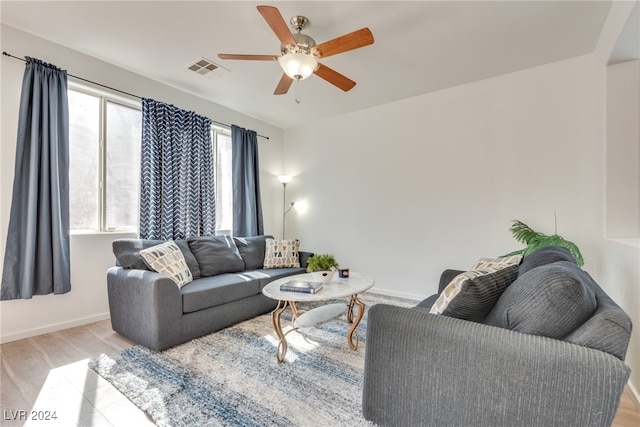 living room with light hardwood / wood-style flooring and ceiling fan