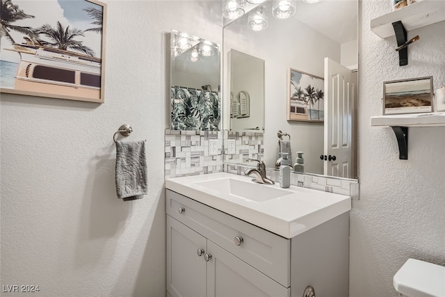 bathroom with tasteful backsplash, vanity, and toilet