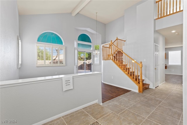 entryway featuring hardwood / wood-style floors, beamed ceiling, and high vaulted ceiling