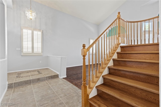 stairs with an inviting chandelier and hardwood / wood-style flooring