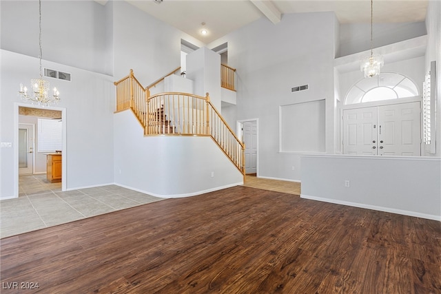 interior space featuring light wood-type flooring, beam ceiling, a chandelier, and high vaulted ceiling