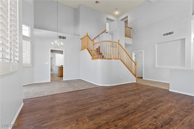 interior space featuring an inviting chandelier, a high ceiling, and hardwood / wood-style floors