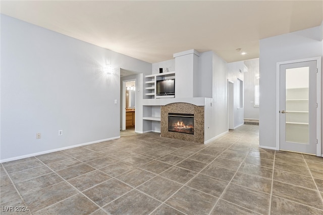 unfurnished living room featuring built in shelves and tile patterned floors