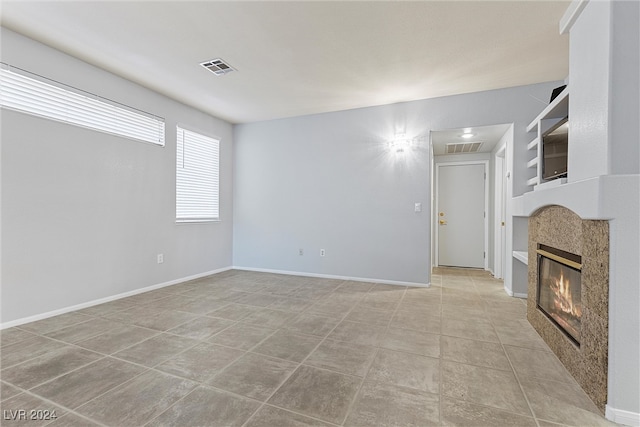 unfurnished living room featuring light tile patterned floors and a tile fireplace