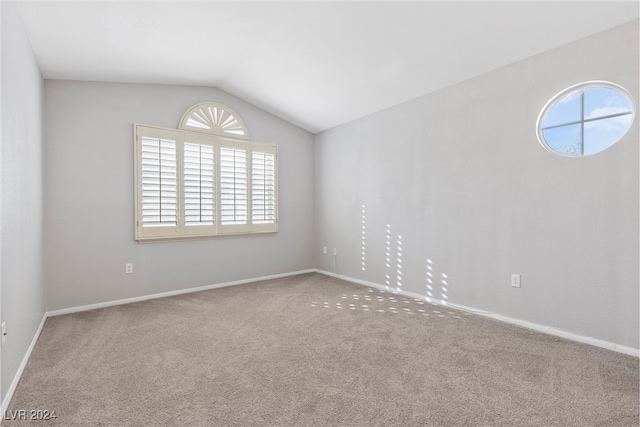 carpeted spare room with lofted ceiling