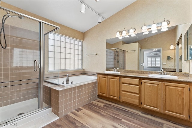 bathroom with vanity, hardwood / wood-style floors, vaulted ceiling, and plus walk in shower