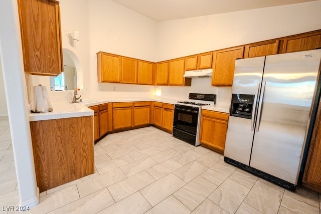 kitchen featuring stainless steel refrigerator with ice dispenser, sink, range, and high vaulted ceiling