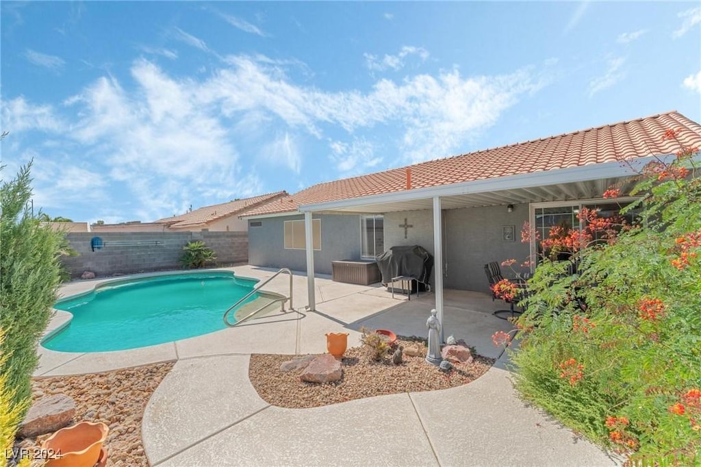 view of swimming pool with grilling area and a patio area