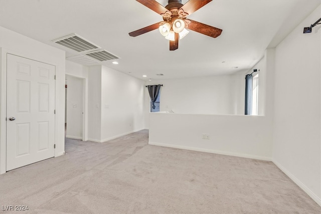 carpeted spare room featuring ceiling fan