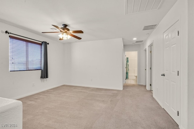 unfurnished room with ceiling fan and light colored carpet