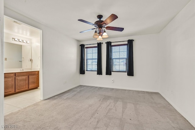 unfurnished room featuring light carpet, ceiling fan, and sink