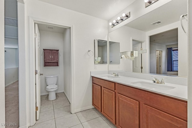 bathroom with toilet, vanity, and tile patterned floors