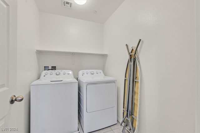 laundry room with washing machine and dryer and light tile patterned floors