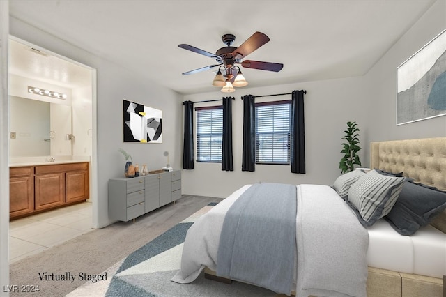 tiled bedroom featuring ceiling fan, sink, and connected bathroom