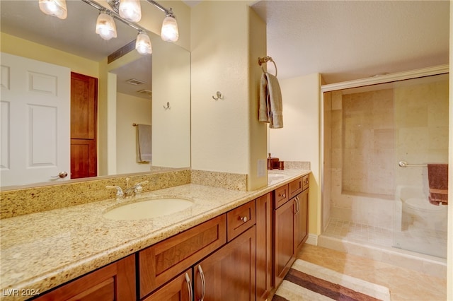 bathroom featuring tile patterned flooring, an enclosed shower, and vanity