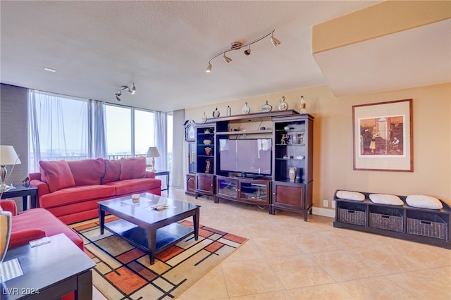 living room with a textured ceiling, track lighting, and light tile patterned flooring