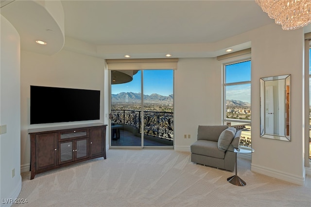 living area with light carpet and a notable chandelier