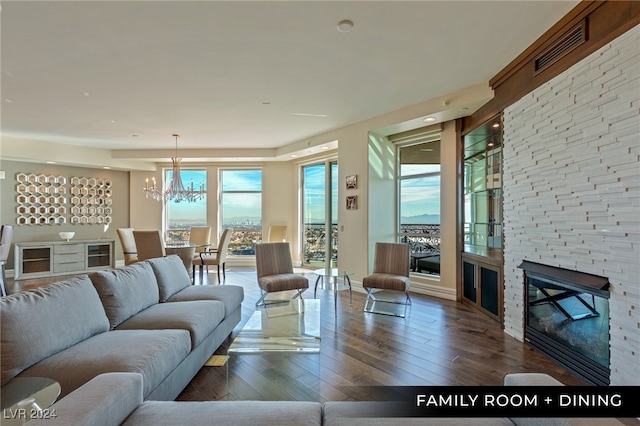 living room featuring a fireplace, hardwood / wood-style floors, and a chandelier