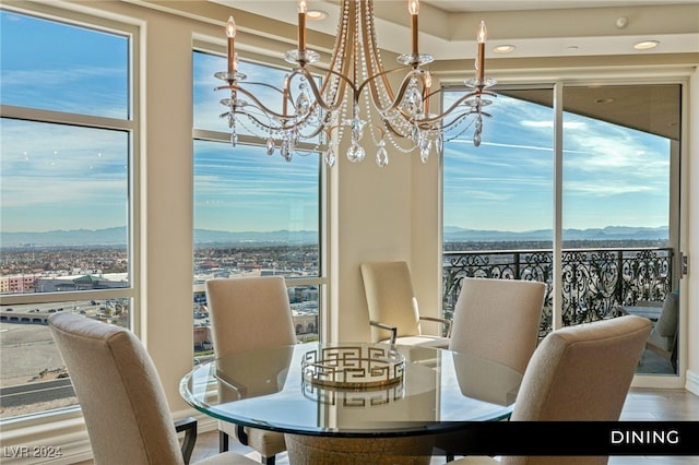 dining space with an inviting chandelier, wood-type flooring, a mountain view, and plenty of natural light