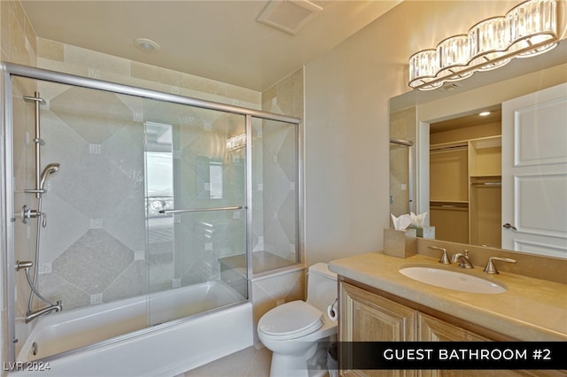 full bathroom with tile patterned floors, shower / bath combination with glass door, vanity, and toilet