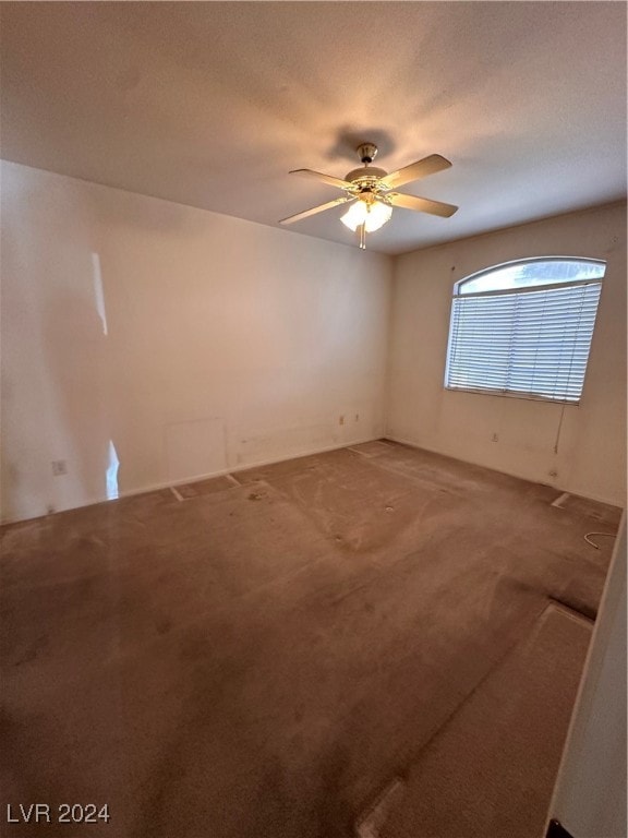 carpeted empty room with a textured ceiling and ceiling fan