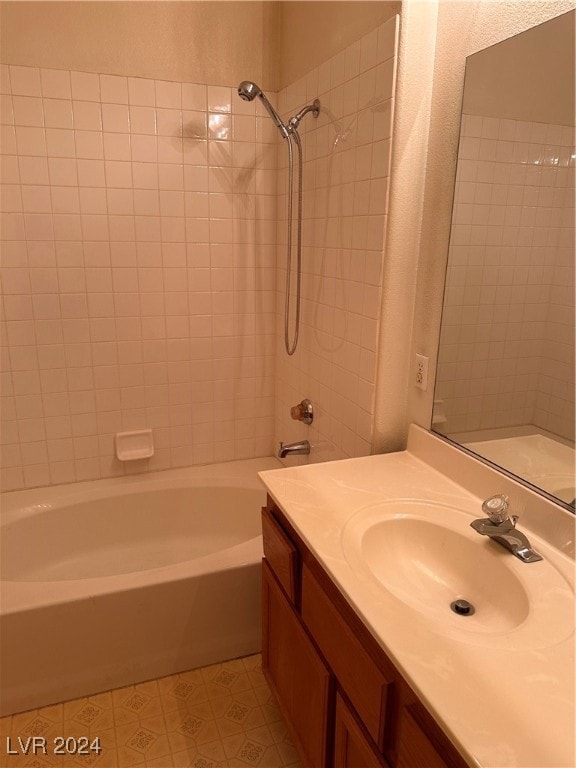 bathroom featuring tiled shower / bath combo and vanity