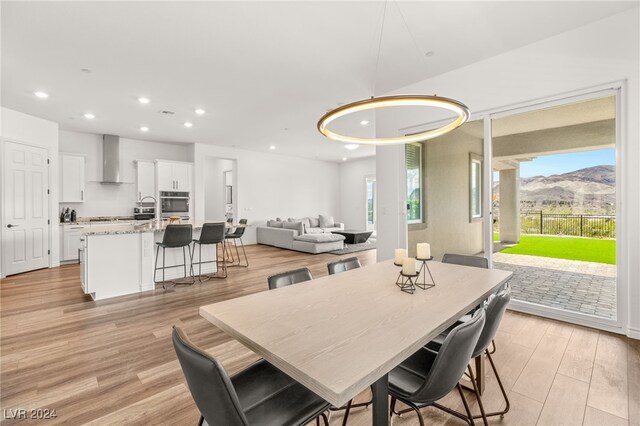 dining area with a mountain view, light hardwood / wood-style floors, plenty of natural light, and sink