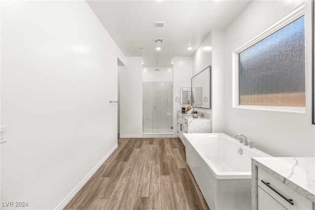 bathroom featuring shower with separate bathtub, vanity, and wood-type flooring