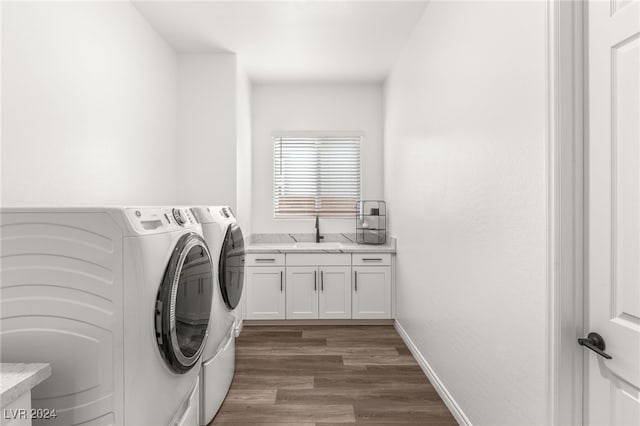 clothes washing area with dark hardwood / wood-style floors, independent washer and dryer, sink, and cabinets