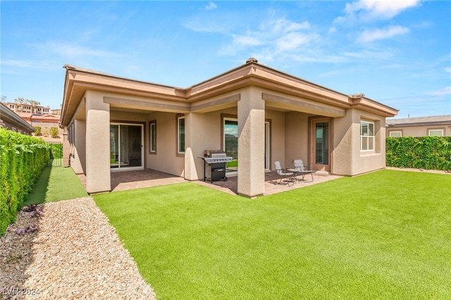 rear view of house with a patio and a yard