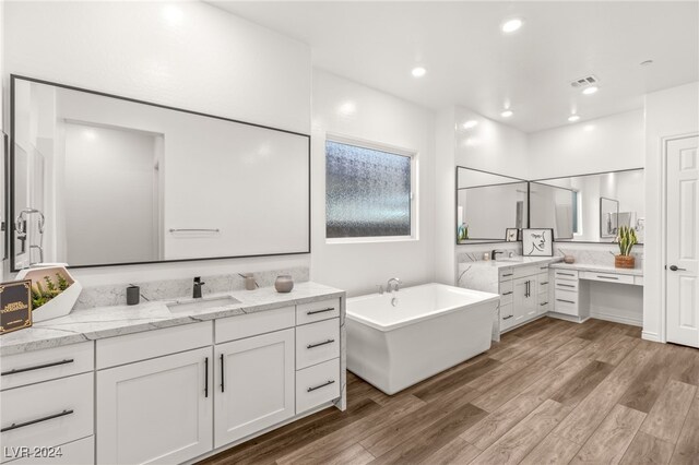 bathroom featuring hardwood / wood-style floors, vanity, and a washtub